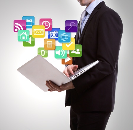 Business man with laptop and colorful application iconsの写真素材