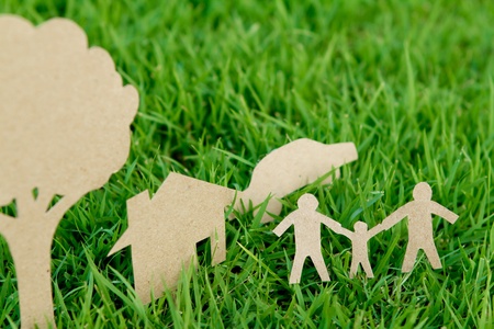 Paper cut of family with house , tree and car on fresh spring green grassの写真素材