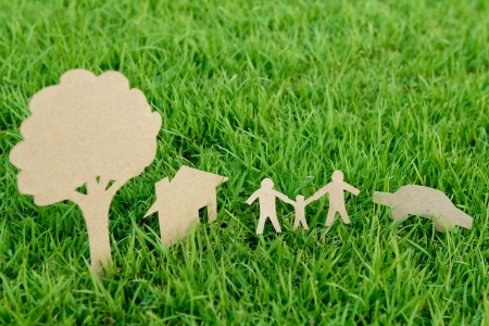 Paper cut of family with house , tree and car on fresh spring green grassの写真素材