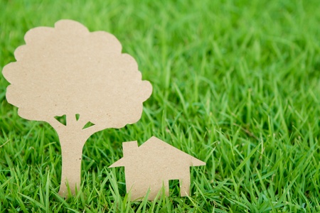 Paper cut of house and tree on fresh spring green grassの写真素材