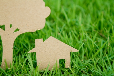 Paper cut of house and tree on fresh spring green grassの写真素材