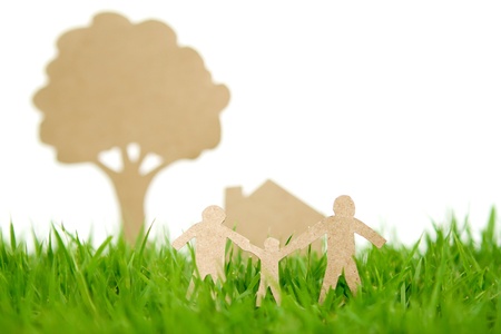Paper cut of family with house and tree on fresh spring green grassの写真素材