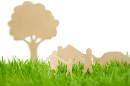 Paper cut of family with house and tree on fresh spring green grassの写真素材