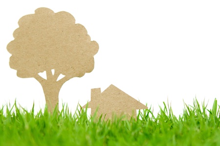 Paper cut of house and tree on fresh spring green grassの写真素材