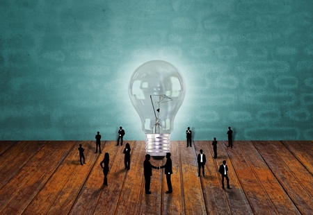 Silhouettes of business people  and light bulbの写真素材
