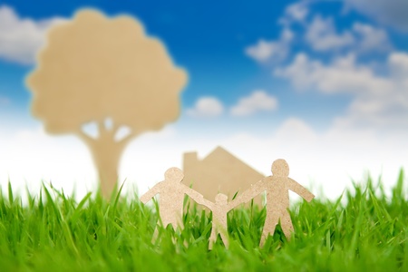 Paper cut of family with house and tree on fresh spring green grassの写真素材