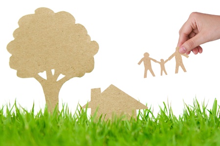 Paper cut of house and tree on fresh spring green grassの写真素材