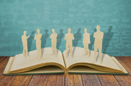 Paper cut of  business man  on old bookの写真素材