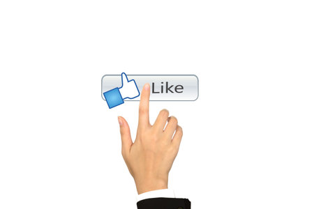 Hand pushing a Like button on a touch screen interface