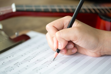 Hand with pencil and music sheetの写真素材