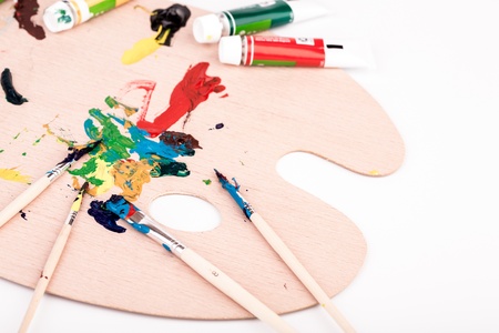 Wooden art palette with paint  brush on white backgroundの写真素材