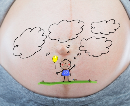 Pregnant woman with little baby painted on her bellyの写真素材
