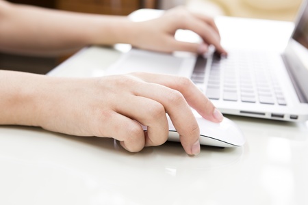 Closeup of business woman hand typing on laptop keyboard with mouseの写真素材