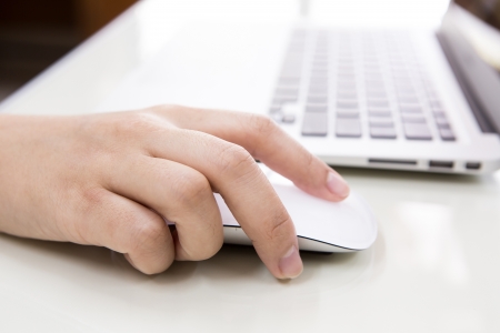 Closeup of business woman hand typing on laptop keyboard with mouseの写真素材