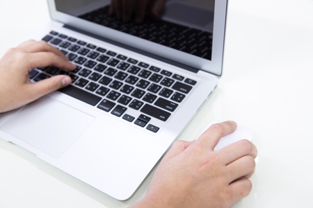 Closeup of business woman hand typing on laptop keyboard with mouseの写真素材