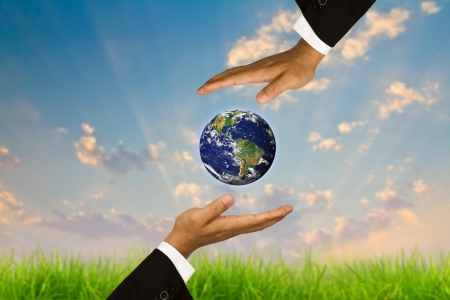 Eco concept : Hand hold globe in bubbles against the sun and the blue skyの写真素材