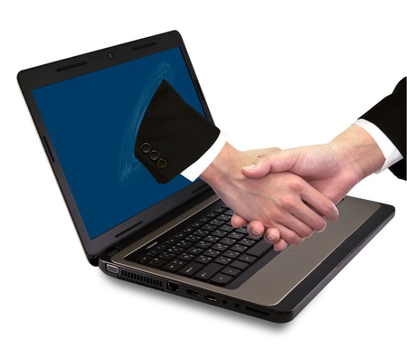 Businessmen shake hands from laptopの写真素材