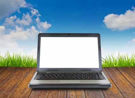 Laptop on wood floor with green grassの写真素材