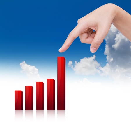 Woman's hand points up the growing graph against the skyの写真素材