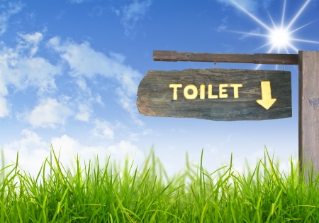 A wooden sign hung over the entrance to a toilet.の写真素材