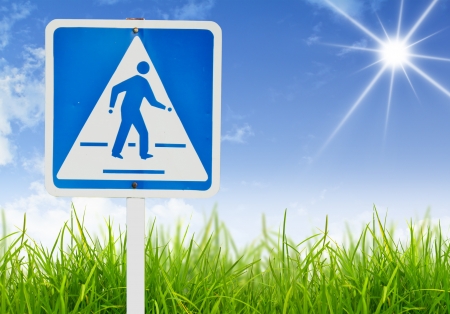 Traffic sign on green grass and blue sky.の写真素材