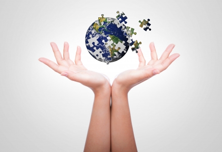 Business concept with a hand building puzzle globeの写真素材