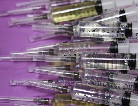 Closeup, Isolated disposable syringe in the row on white background