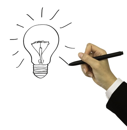 Business man with a pen drawing light bulbの写真素材