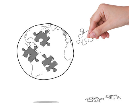 Business concept with a hand building puzzle globeの写真素材