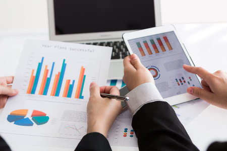 Close-up of  business team using digital tablet with financial diagram