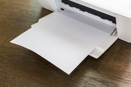 Printer with blank paper on a wood tableの写真素材
