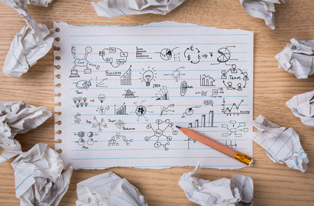 Business concept and graph drawing on White note book paper with  pencil and crumpled paperの写真素材