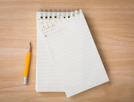 Note book with pencil on a wooden desk