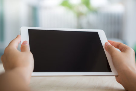 Woman hand hold white tablet with blank empty screen