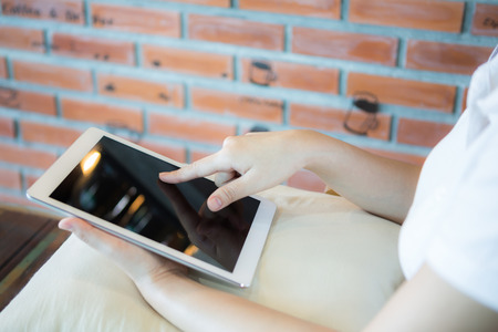 Woman hand hold white tablet with blank empty screenの写真素材