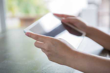 Woman hand touch white tablet with blank empty screen