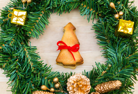Christmas wreath with cookies over Wooden Background