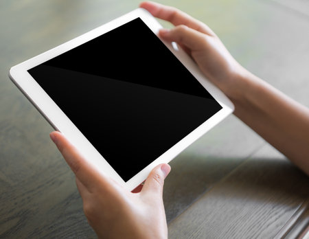 Woman hand touch white tablet with blank empty screen