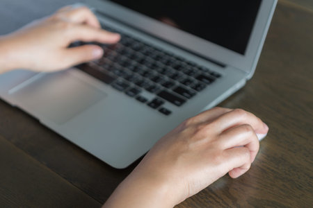 Closeup of business woman hand typing on laptop keyboard