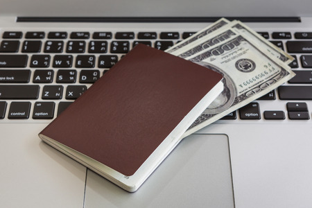 Passport with us dollars on laptopの写真素材