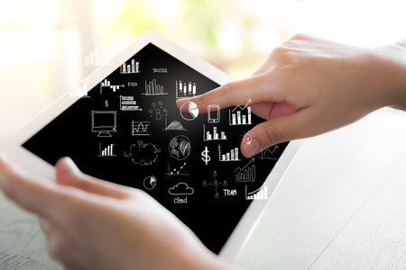 Woman hand hold white tablet with graph and chart symbols