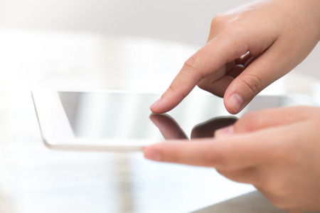 Woman hand touch white tablet with blank empty screenの写真素材