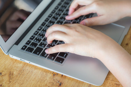Closeup of business woman hand typing on laptop keyboard