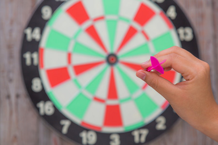 Hand holdin red arrow and throwing to dart boardの写真素材