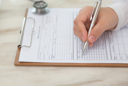 Hand of doctor writing on prescription