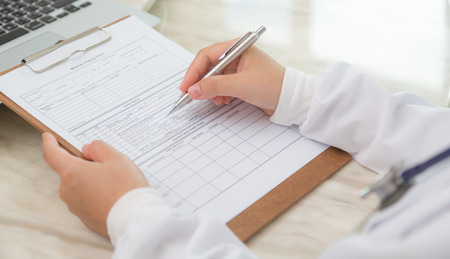 Hand of doctor writing on prescriptionの写真素材