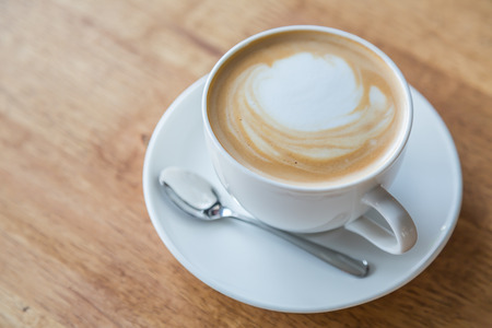 Coffee in white cup on wood tableの写真素材