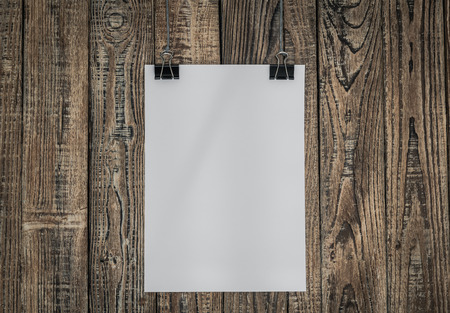 Black clip and White paper hang on wood backgroundの写真素材