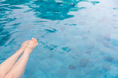 Female legs in the swimming pool waterの写真素材