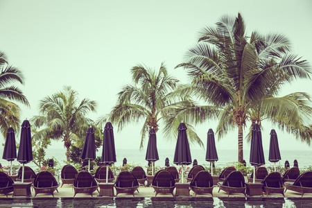 Poolside with chairs and palm trees ( Filtered image processed vintage effect. )のeditorial素材